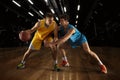 Poster with two young basketball players playing basketball in playground over dark background with flashlights Royalty Free Stock Photo