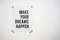 Poster on white wall with the quote make your dreams happen abstract background texture Royalty Free Stock Photo