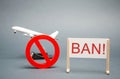 A poster with the word Ban. The sign of the ban and a miniature toy aircraft. Ban on flights of civil aircraft. Forbidden zone.