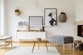 Posters and baskets on white wall in bright flat interior with w