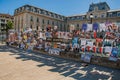 Posters of theatrical plays affixed to a building grid in the city center of Avignon.