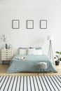 Posters on white wall above green bed in bedroom interior with s Royalty Free Stock Photo