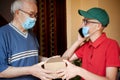 The postman brings the package to the elderly person