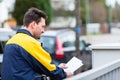 Postman delivering letters to mailbox of recipient Royalty Free Stock Photo