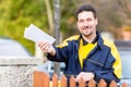 Postman delivering letters to mailbox of recipient Royalty Free Stock Photo