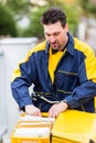 Postman delivering letters to mailbox of recipient Royalty Free Stock Photo