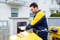 Postman delivering letters to mailbox of recipient Royalty Free Stock Photo