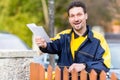 Postman delivering letters to mailbox of recipient Royalty Free Stock Photo