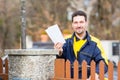 Postman delivering letters to mailbox of recipient Royalty Free Stock Photo