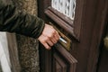 Close-up. The postman puts a letter or newspaper or magazine in the mailbox at the door of a residential building or a