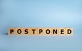 Postponed - words from wooden blocks with letters, postponed concept, top view background Royalty Free Stock Photo