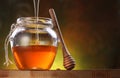 Pot is being filled with honey and a drizzler. Royalty Free Stock Photo