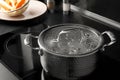 Pot with boiling water on stove in kitchen