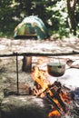 The pot is burning near the tent in the forest at night. Beautiful campfire in a tourist camp in the wild Royalty Free Stock Photo