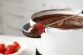 Pot with chocolate fondue and dipped strawberry Royalty Free Stock Photo