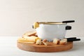 Pot of delicious cheese fondue and fork with bread Royalty Free Stock Photo