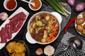 Pot of delicious vegetable soup with meat, noodles and ingredients on black wooden table, flat lay Royalty Free Stock Photo