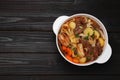 Pot of delicious vegetable soup with meat, noodles and ingredients on black wooden table, top view. Space for text Royalty Free Stock Photo