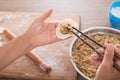A pot of dumpling stuffing and two hands are making dumplings Royalty Free Stock Photo
