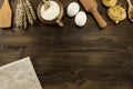 Pot of flour, wheat ears, pasta, eggs, kitchen utensils on wooden background. Royalty Free Stock Photo