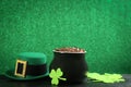 Pot of gold coins, hat and clover leaves on black stone table against green background, space for text. St. Patrick`s Day Royalty Free Stock Photo