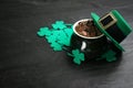 Pot of gold coins, hat and clover leaves on black stone table, space for text. St. Patrick`s Day celebration Royalty Free Stock Photo