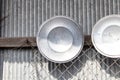 Pot lid Kitchenware various sized metal pan pot hanging in row on hooks attached on wall galvanized sheet. Royalty Free Stock Photo