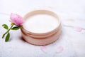 Pot of moisturizing face cream and beautiful flower on a white wooden background. natural organic cosmetic facial. Royalty Free Stock Photo