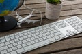 Pot plant, globe, keyboard and airplane model on wooden plank