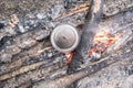 Pot of preparing food stands on the coals campfire, camp. Top view.