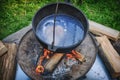 Pot of soup on a summer day, a tourist camp. A cauldron with a piece of meat in broth boiling on fire