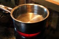 A pot of water simmering on a hot stove element