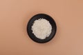 Potassium sorbate, granular potassium salt of sorbic acid in black dish, top view. Food additive E202. Potassium sorbate used as