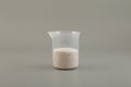 Potassium sorbate, potassium salt of sorbic acid in a plastic measuring cup. Chemical granular powder. White salt soluble in water