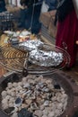 Potato in alumnium foil baked on charcoal barbecue grill outdoor Royalty Free Stock Photo