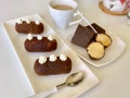 Potato cake, cut in two cake pops and chocolate pieces. Lie on the plates. Nearby is a cup of coffee with milk Royalty Free Stock Photo