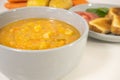 Potato carrot soup in grey ceramic bowl, white background