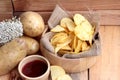 Potato chip and fresh potatoes on wood background Royalty Free Stock Photo