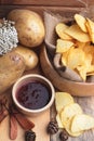 Potato chip and fresh potatoes on wood background Royalty Free Stock Photo