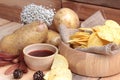 Potato chip and fresh potatoes on wood background Royalty Free Stock Photo