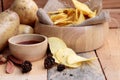 Potato chip and fresh potatoes on wood background Royalty Free Stock Photo