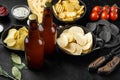 Potato chips. Beer snacks, sauce, on black stone background Royalty Free Stock Photo