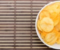 Potato chips in bowl on bamboo mat