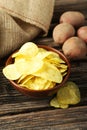 Potato chips in bowl on the brown wooden background Royalty Free Stock Photo