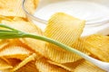 Potato chips close-up with bowl with sour cream and fresh green onion. Food background Royalty Free Stock Photo