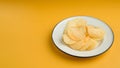 Potato chips or crisps in a white dish on an orange background Royalty Free Stock Photo