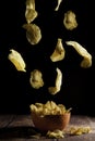 Potato chips falling into an orange ceramic bowl Royalty Free Stock Photo