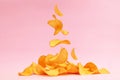 Potato chips fly on a pink background. Levitation. Royalty Free Stock Photo