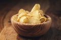 Potato chips with herbs in wood bowl on rustic table Royalty Free Stock Photo