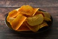 Potato chips over wooden background. Salty crispy snack